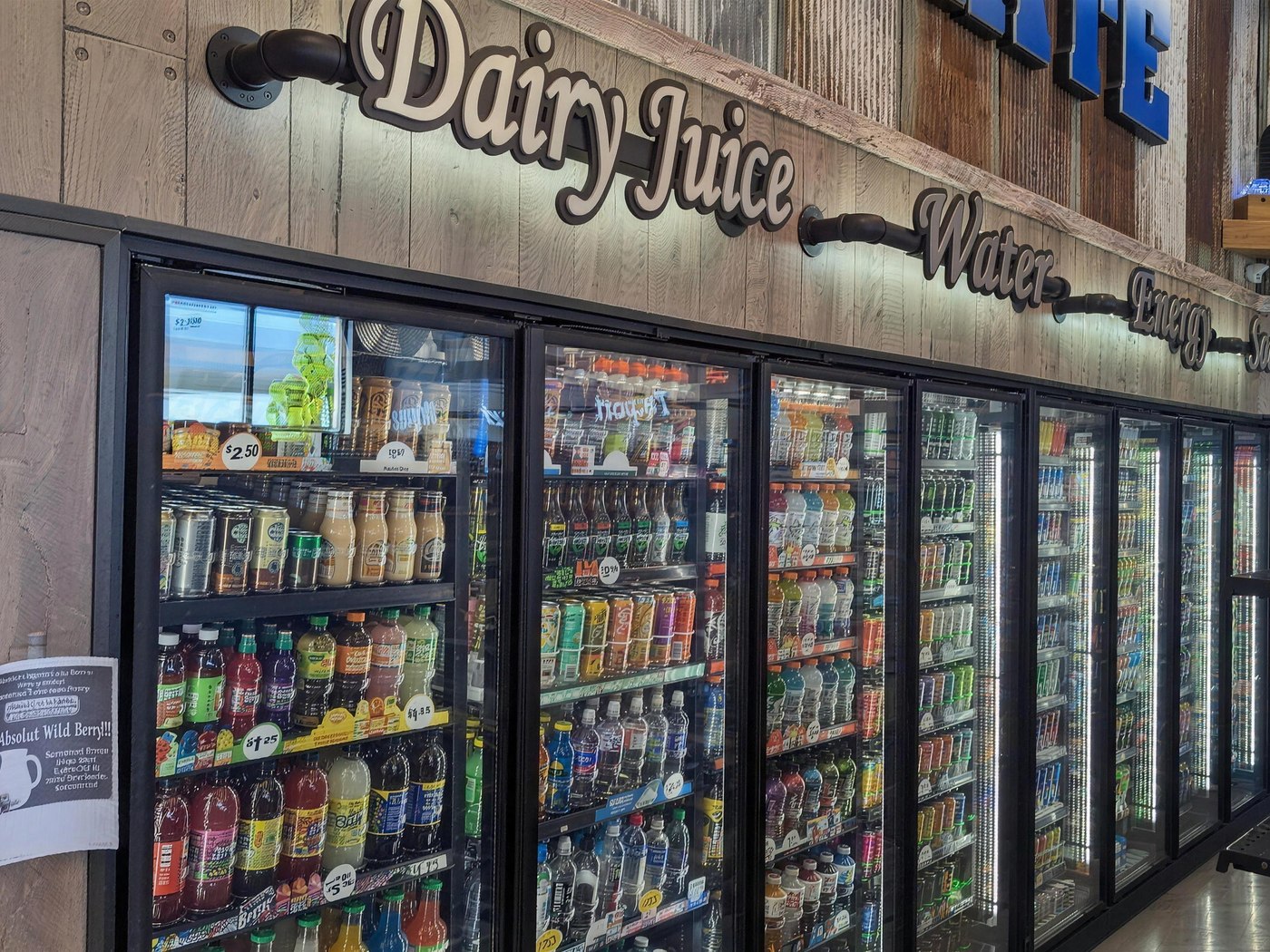 The cooler wall — Dairy, Juice, Water, Energy and Soda doors stocked floor to ceiling