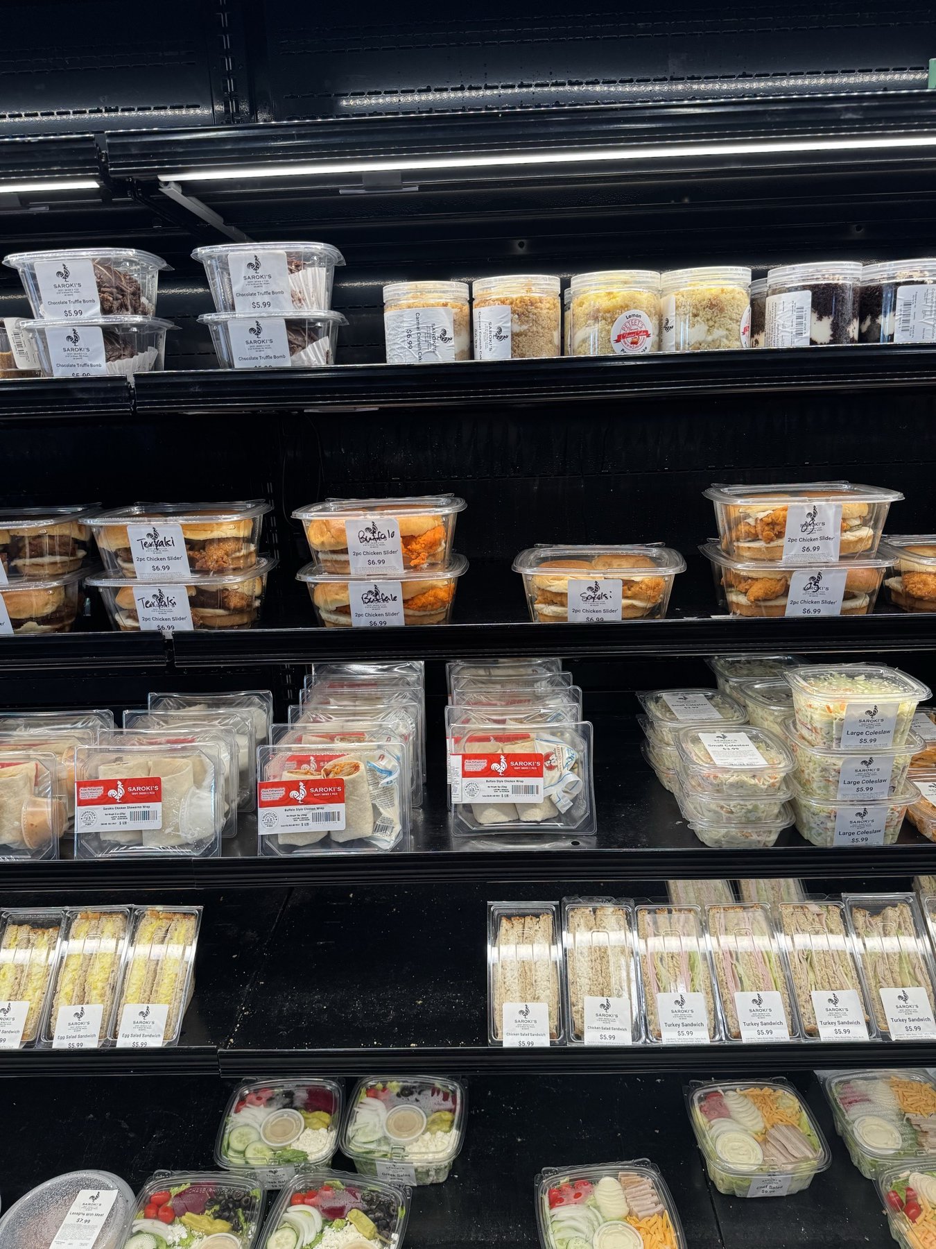Fresh salads and pre-packaged sandwiches in the cold case at Wixom