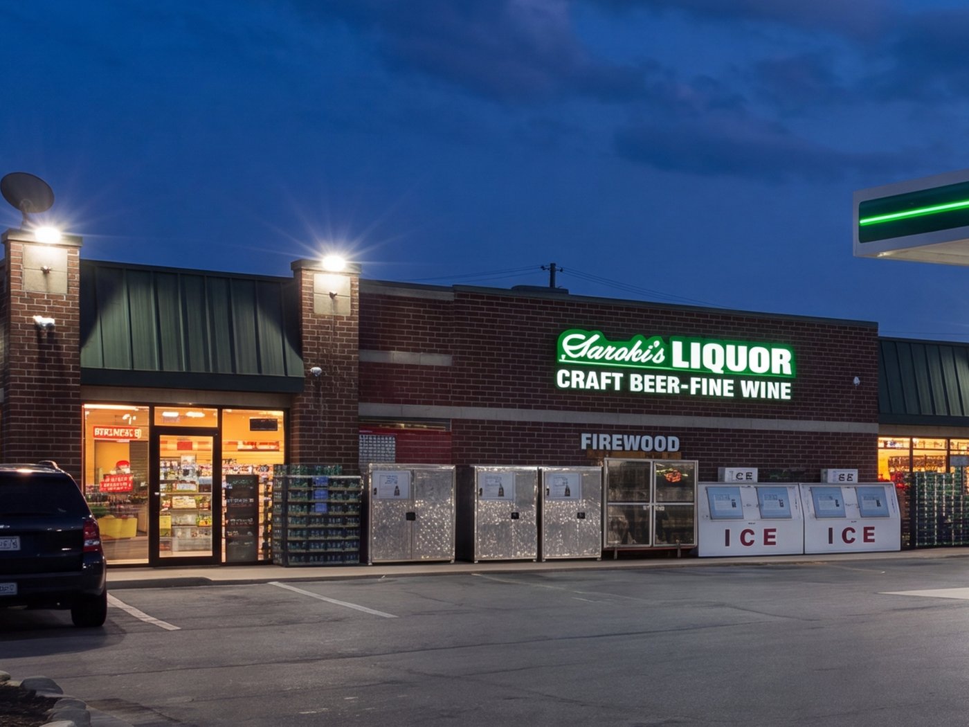 The Saroki's Liquor storefront in Wixom lit up at night, with the ice merchandisers out front